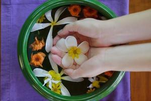 mano femminile e fiore in acqua foto