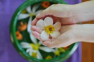 mano femminile e fiore in acqua foto