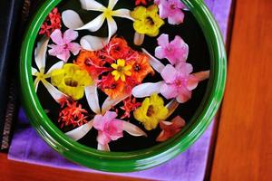 tazza d'acqua con bellissimi fiori sullo sfondo foto