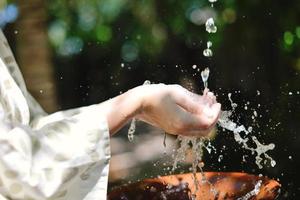 spruzzi fresco acqua su donna mani foto