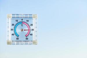 termometro esterno sulla finestra di casa e sul cielo blu foto