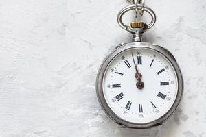 Due minuti per dodici su retrò orologio su calcestruzzo foto