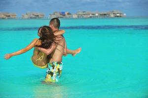 contento giovane coppia godendo estate su spiaggia foto