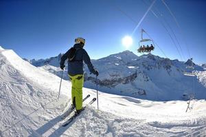 sciare sulla neve fresca nella stagione invernale in una bella giornata di sole foto