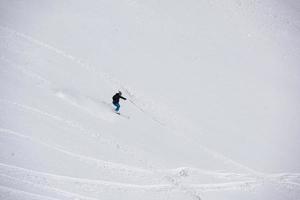 sciatore freeride che scia nella neve farinosa profonda foto