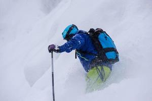 sciatore freeride che scia in discesa foto