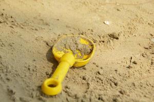 giallo vanga bambini giocattolo era posto su sabbia a il spiaggia. foto