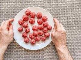 mani dell'uomo che preparano le polpette con carne macinata cruda foto