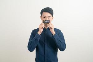 giovane asiatico in possesso di carta di credito foto