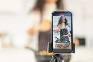 donna latina che gira video e cucina in cucina foto