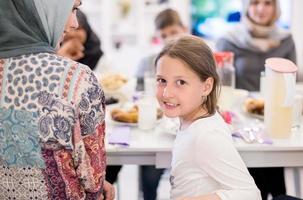 carino poco ragazza godendo iftar cena con famiglia foto