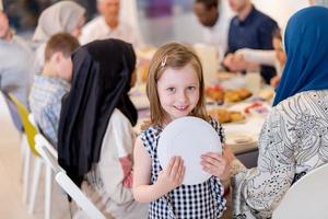 carino poco ragazza godendo iftar cena con famiglia foto