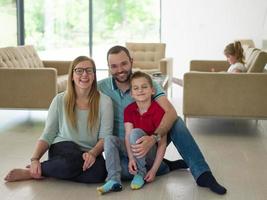 famiglia con poco ragazzo gode nel il moderno vivente camera foto