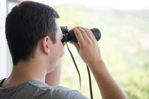 uomo con il binocolo foto