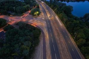 vista aerea notturna delle autostrade britanniche con strade e traffico illuminati foto