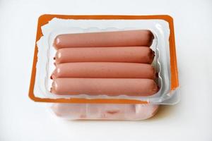 succoso carne salsicce nel plastica confezione su un' bianca sfondo. salsicce nel il gruppo.carne semilavorato Prodotto nel un' pacchetto. foto