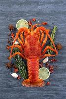 cucinato bollito aragosta, delizioso cena frutti di mare pasto impostato con coltello e forchetta su nero pietra ardesia sfondo, ristorante menù disegno, superiore Visualizza, alto foto