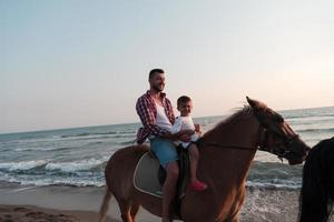 padre e figlio godere equitazione cavalli insieme di il mare. selettivo messa a fuoco foto