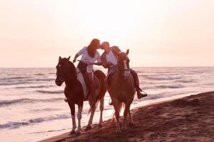 un' amorevole coppia nel estate Abiti equitazione un' cavallo su un' sabbioso spiaggia a tramonto. mare e tramonto nel il sfondo. selettivo messa a fuoco foto