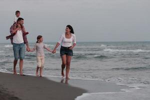 famiglia raduni e socializzazione su il spiaggia a tramonto. il famiglia passeggiate lungo il sabbioso spiaggia. selettivo messa a fuoco foto