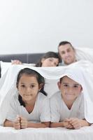 contento giovane famiglia nel loro Camera da letto foto