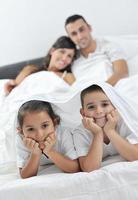 contento giovane famiglia nel loro Camera da letto foto