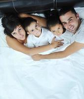 contento giovane famiglia nel loro Camera da letto foto