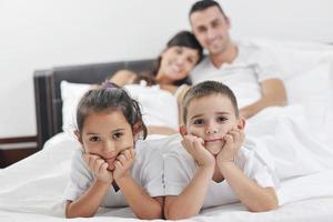 contento giovane famiglia nel loro Camera da letto foto