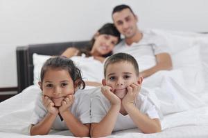 contento giovane famiglia nel loro Camera da letto foto