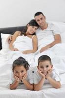 contento giovane famiglia nel loro Camera da letto foto