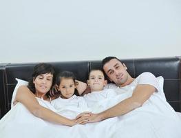 contento giovane famiglia nel loro Camera da letto foto