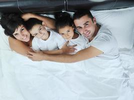 contento giovane famiglia nel loro Camera da letto foto