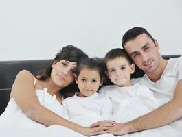 contento giovane famiglia nel loro Camera da letto foto