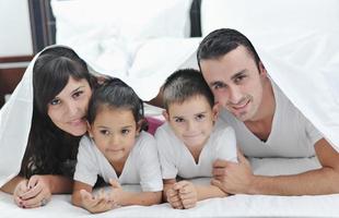 contento giovane famiglia nel loro Camera da letto foto