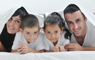 contento giovane famiglia nel loro Camera da letto foto