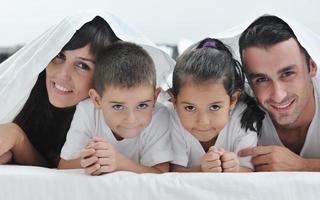 contento giovane famiglia nel loro Camera da letto foto