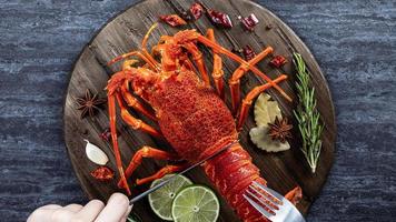 cucinato bollito aragosta, delizioso cena frutti di mare pasto impostato con coltello e forchetta su nero pietra ardesia sfondo, ristorante menù disegno, superiore Visualizza, alto foto