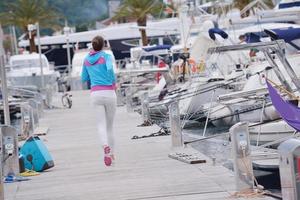donna che fa jogging nel porto turistico foto