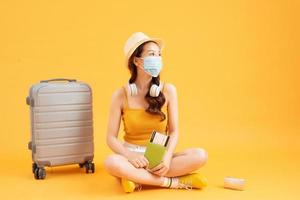 giovane asiatico femmina turista indossare maschera di nuovo normale stile di vita trasporto un' zaino e passaporto per partire per viaggio ,proteggere te stesso a partire dal virus foto