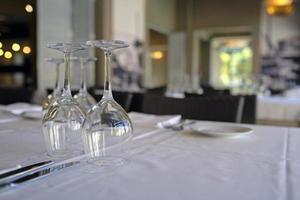 ristorante tavolo con bicchieri di vino pronto per cena ospiti foto