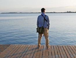 uomo guardare su a un' lago nel il pomeriggio ore foto