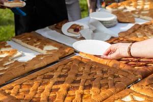 mano con carta piatto raggiunge per porzione di torta foto