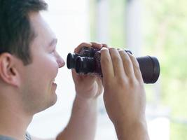 uomo guardare con binocolo foto