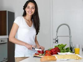 giovane donna che cucina in cucina foto