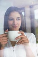 bellissimo giovane donna bevanda primo mattina caffè foto