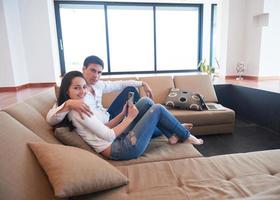 coppia a moderno casa utilizzando tavoletta computer foto