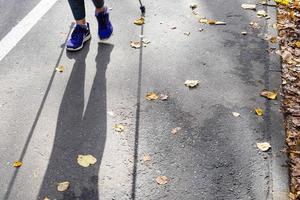 gambe e ombra di camminatore di nordico a piedi foto