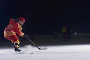 adolescente ghiaccio hockey giocatore nel azione foto