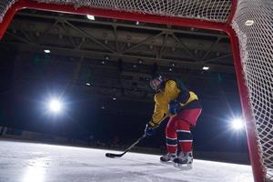 adolescente ghiaccio hockey giocatore nel azione foto