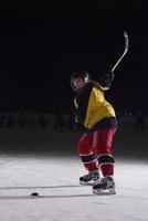adolescente ghiaccio hockey giocatore nel azione foto